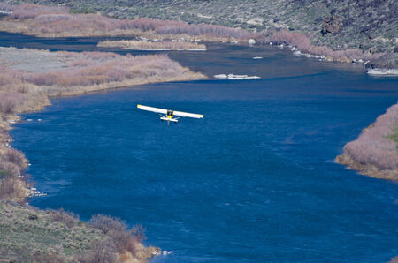 Yellow and White Airplane Flying Through the Canyonの写真素材