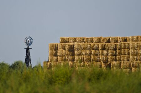 Windmill and Hay Supply Stacked in Autumnの写真素材