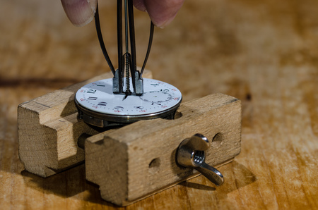 Watch Repair: Hands Remover About to Lift The Hands from a Pocket Watch Movementの写真素材