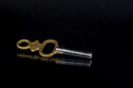 Antique Brass Pocket Watch Key Laying In The Darknessの写真素材