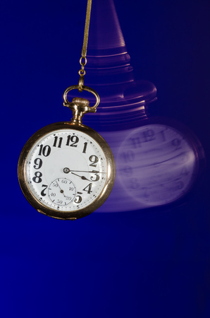 Swinging Pocket Watch Beckoning You to Look More Closelyの写真素材