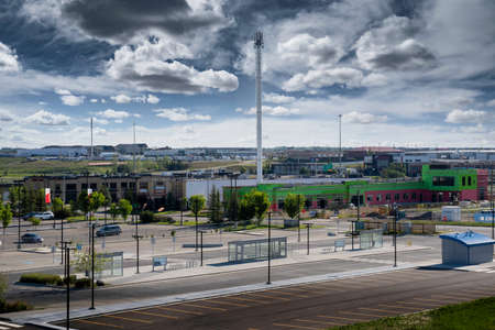 Airdrie Alberta Canada, August 31 2021: A cell phone tower stands tall next to a public transit transfer station with parking stalls in a Canadian City.のeditorial素材