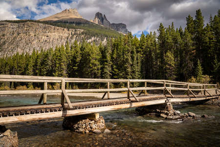 A wooden log bridge over a clear mountain creek in Banff National Park Canada.の写真素材