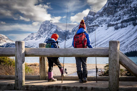 Banff Alberta Canada, October 17 2021: A brother and sister fishing off a wooden bridge in the Rocky Mountainsのeditorial素材