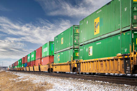 Calgary Alberta Canada, February 04, 2022: A CP Rail train carrying sea cans and cargo containers through the Ogden rail yard.のeditorial素材