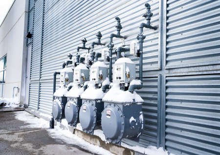Calgary Alberta Canada, March 04 2022: Commercial natural gas meters covered in snow on a building exterior.のeditorial素材