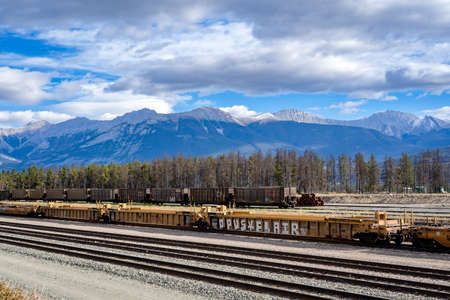 Jasper Alberta Canada, September 29 2021: Coal cars and shipping container railway cars sit empty at a rail yard in the Canadian Rockies.のeditorial素材