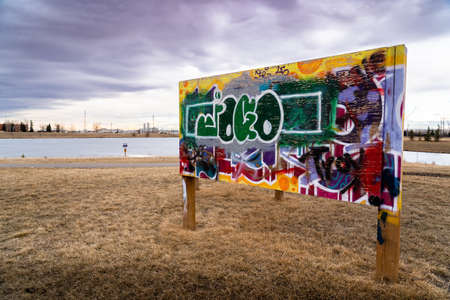 Airdrie Alberta Canada, April 04 2022: A legal graffiti wall at an off leash dog park next to a storm water retention pond for street artists.のeditorial素材
