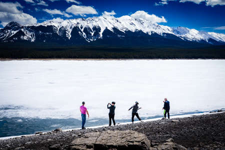 Kananaskis Alberta Canada, May 15 2022: Tourists taking pictures along the lakeshore of Lower...