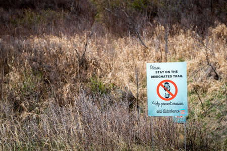 Cochrane Alberta Canada, May 22 2022: A no tresspassing sign indicating a sensitive habitat area for park users.のeditorial素材