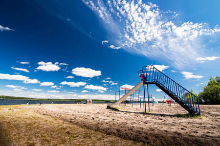 Boyle Alberta Canada, July 20 2020: A young child rides a slide at a public beach during summer vacation at Skeleton Lake.のeditorial素材