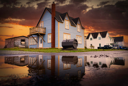 Bonavista Newfoundland Canada, September 14 2022: Sunset road puddle reflection of rustic beach homes on the Avalon peninsula at an East Coast Village.のeditorial素材