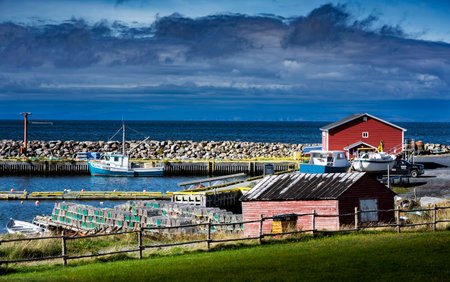 Whiteway Newfoundland Canada, September 26 2022: Fishing boats and lobster traps stacked on a dock at a small harbour inlet on the Canadian East Coast.のeditorial素材