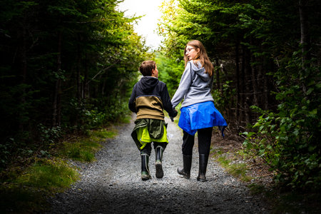 Skerwink Trail Newfoundland Canada, September 22 2022: Brother and sister walking hand in hand under...