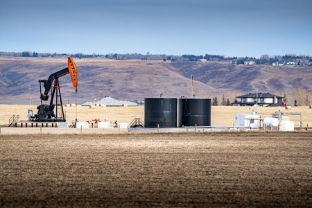 Pump jack working on a rural property for the oil and gas industry at Springbank Rocky View County Alberta Canada.の写真素材