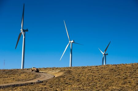 Dump truck beneath wind turbines in the desertの写真素材