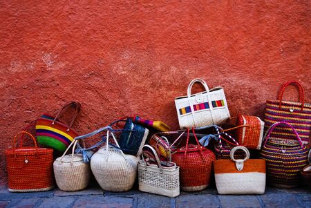 Luggage and bags displayed by a red wall.の写真素材