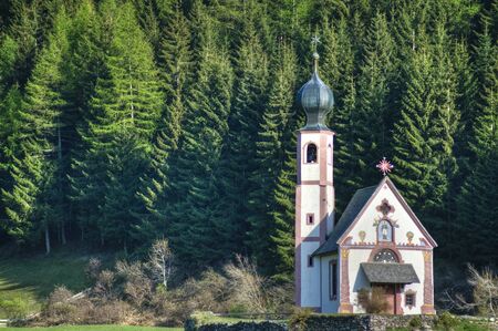 Church with onion dome steeple in Dolomite mountains of northern Italyの写真素材