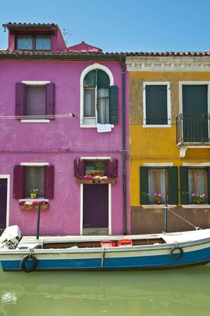 Canal, boat and colorful houses in Burano Italyの写真素材