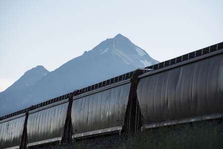 Freight train with hopper cars beneath mountains