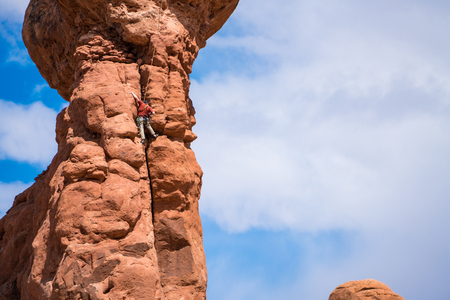 Rock climber on pinnacle in Arches national Park, Utahの写真素材