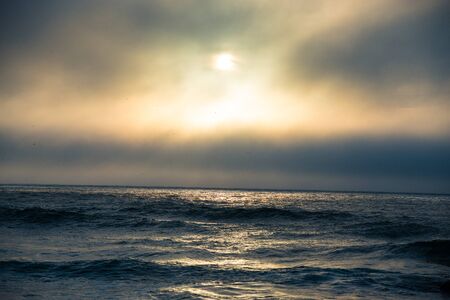 Waves and the setting sun on the Pacific ocean in Oregonの写真素材
