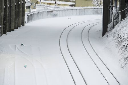 Curving railroad tracks covered with fallen snowの写真素材