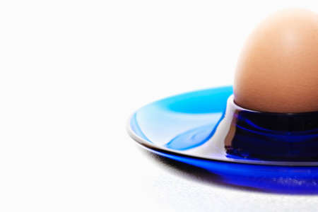 Egg in a blue eggcup on white background