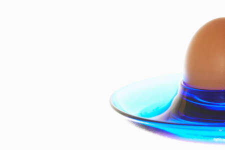 Egg in a blue eggcup on white background