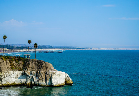 A beautiful gazebo on the rocks and in the distance a huge beach with a long pier that stretches out into the Pacific.の写真素材