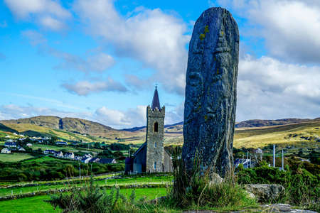 The standing stone is called a Turas it was created between the eighth and ninth century it stands about one hundred yards away from the Church of Ireland in Glencolmkille county Donegal.の写真素材