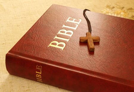 Red Bible book and wooden cross on desktopの写真素材