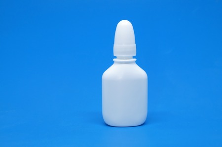 Nasal spray and dropper isolated on blue background. Place for your logo. 