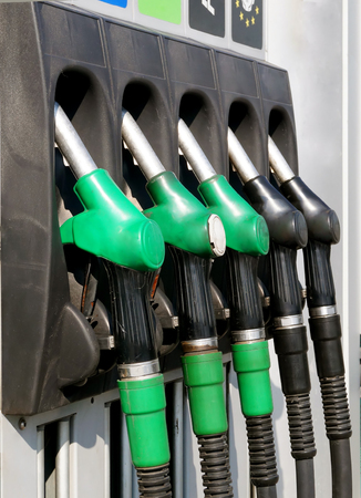 Close-up gasoline pistols on column for refueling. Concept of price fluctuations on automobile fuel.