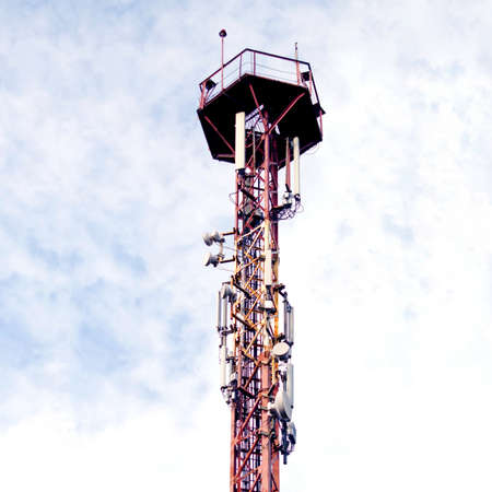 Communication tower 3G or 4G network telephone cellsite silhouette on blue sky with clouds....