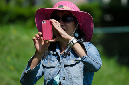 Young woman using smart phone to make photoの写真素材