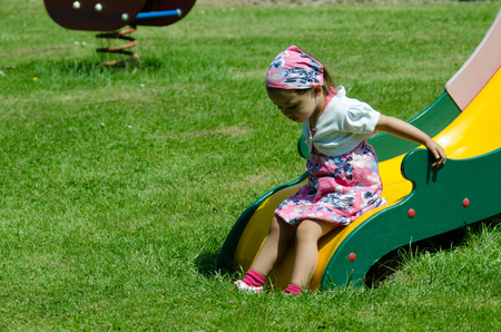 Young girl playing on slideの写真素材