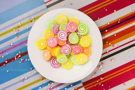 a swirly candy on the plate with colorfull background (landscape)