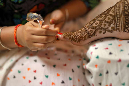 HEENA ART IN YELLOW BACKGROUND ISOLATED HAND FEMALE HAND BEAUTIFUL ART IN HAND | UNIQUE DESIGN IN HANDの写真素材