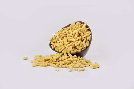 Gathiya Indian Namkeen Bhavnagari Gathiya or Ganthiya. Besan Gathiya Popular Gujarati snack made from gram flour (chickpea flour), isolated served in Yellow bowl on white background. Deep fried snacksの写真素材