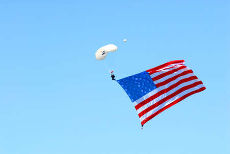 The American flag trails a patriotic skydiver.の写真素材