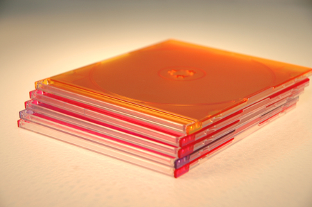 A stack of colored  CD-ROM cases against a white background.の写真素材