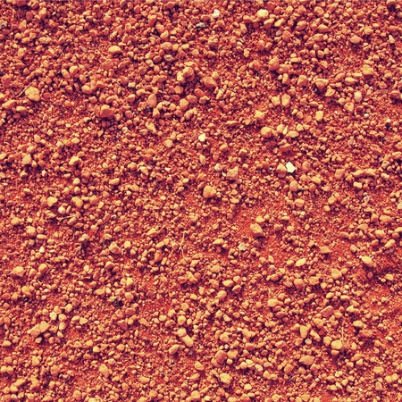 Dry light red crushed bricks surface on outdoor tennis ground. Detail of rough textureの写真素材