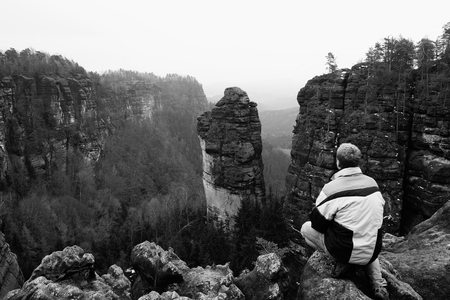 High tourist hiker man on the rock peak  in rocky mountainsの写真素材