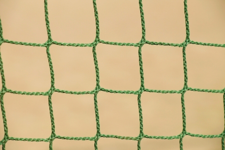 Detail of crossed soccer nets, football in soccer goal net with natural grass on football playground in the backgroundの写真素材