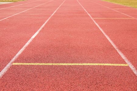White lines and texture of running racetrack, red rubber racetracks in outdoor stadiumの写真素材