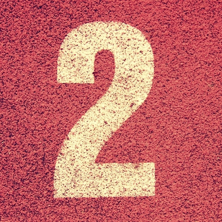 White track number on red rubber racetrack, texture of running racetracks in small stadiumの写真素材