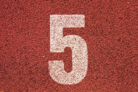 White track number on red rubber racetrack, texture of running racetracks in small stadiumの写真素材