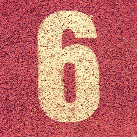 White track number on red rubber racetrack, texture of running racetracks in small stadiumの写真素材