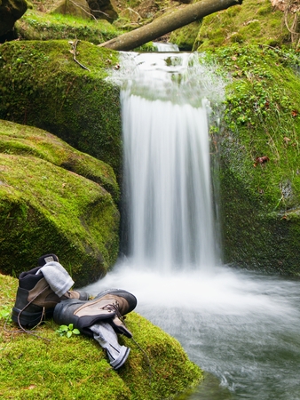 Hiker high boots and sweaty grey socks. Resting on the boulder at the  nice mountain streamの写真素材